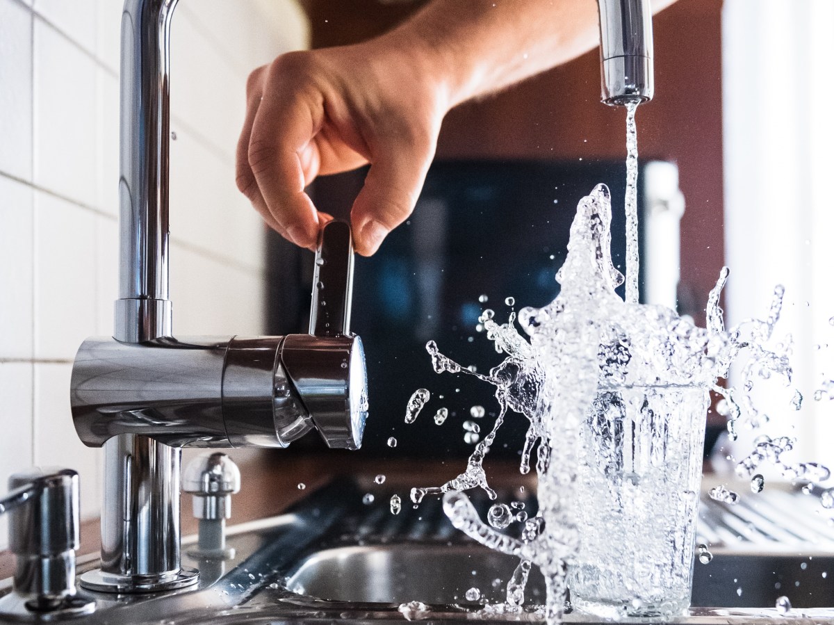 Water from a tap overflowing a glass