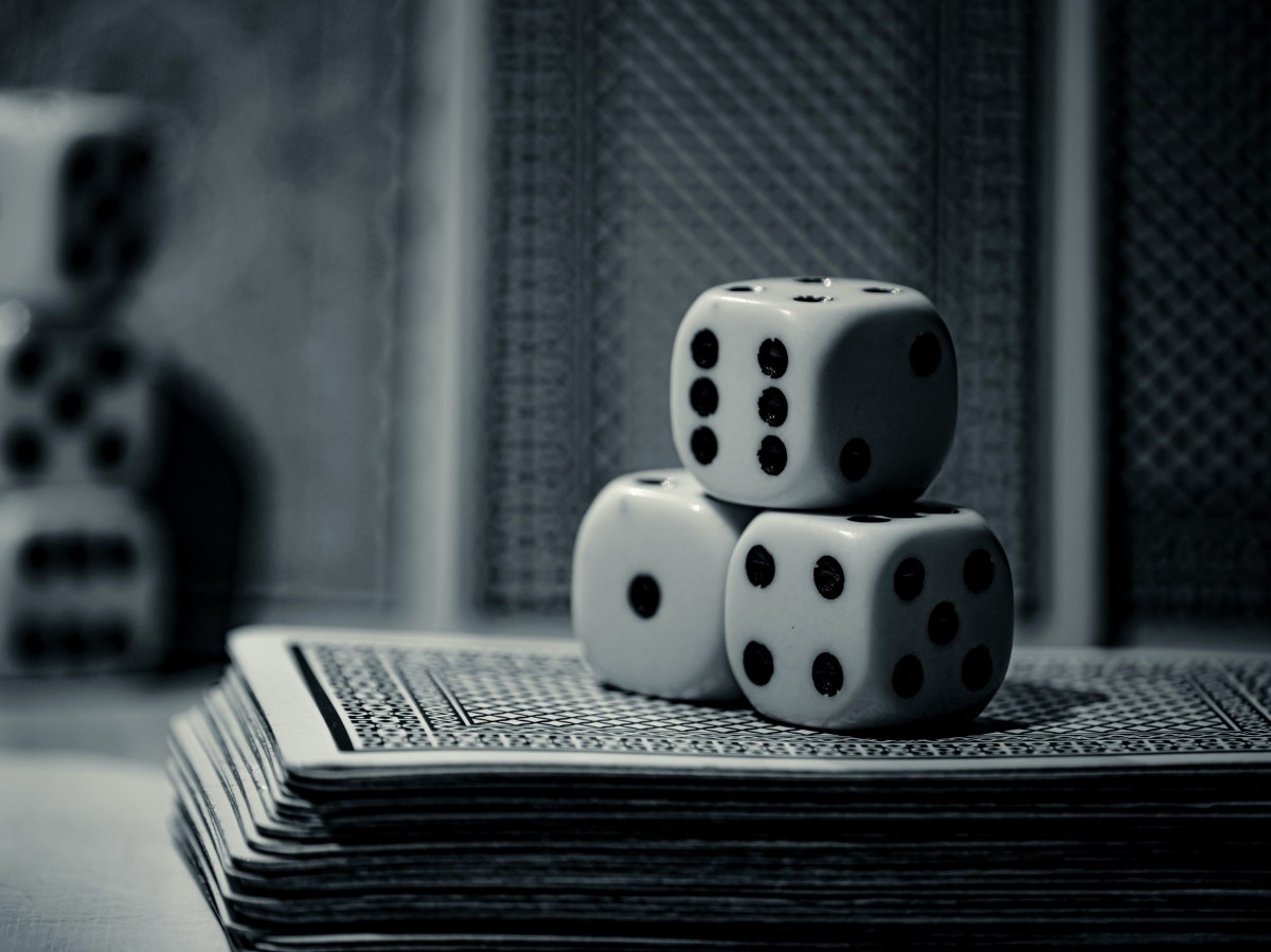 Three dice stacked on a deck of cards